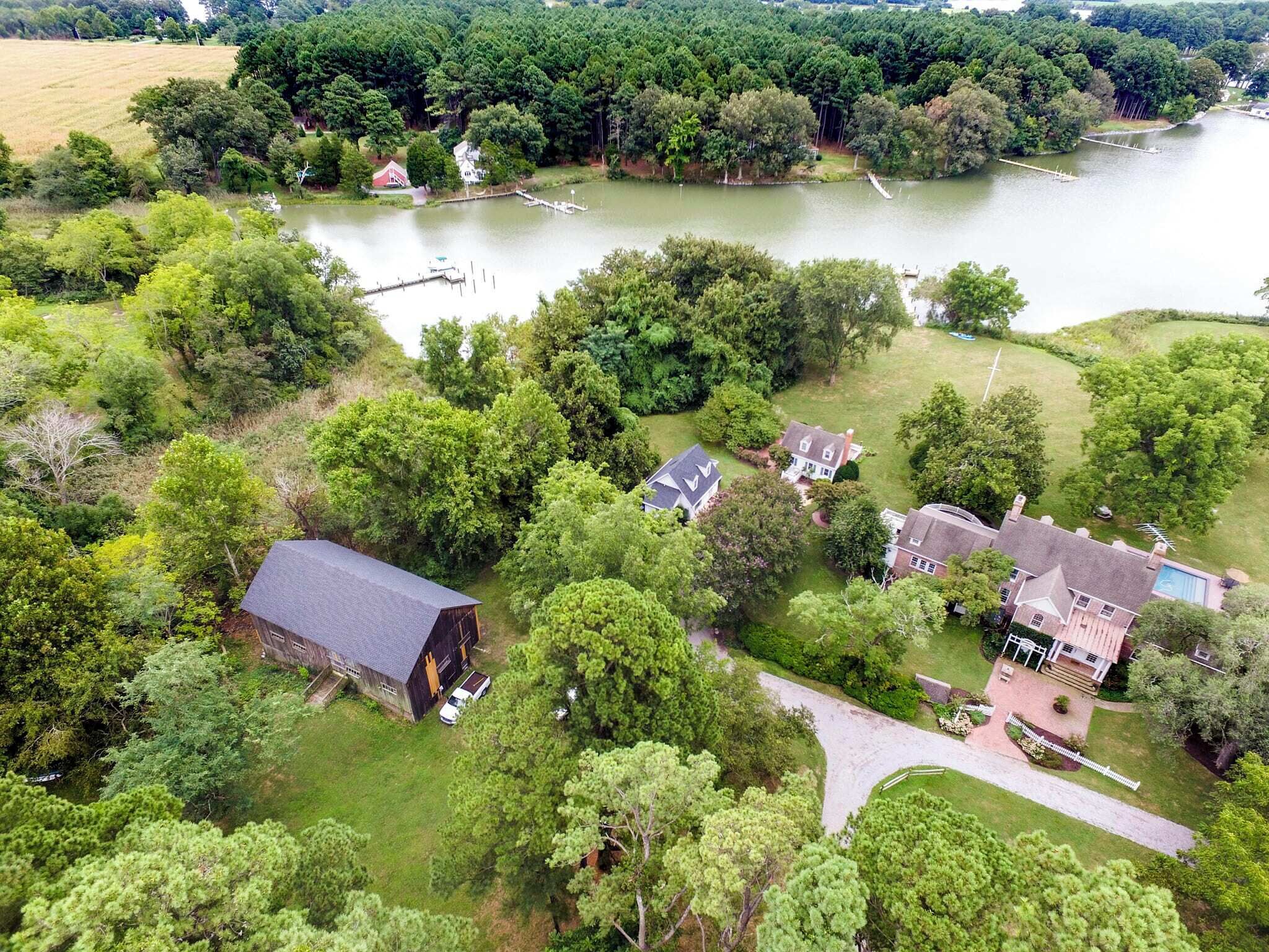 An aerial view of a residential area with houses, a dock, and a lake.
