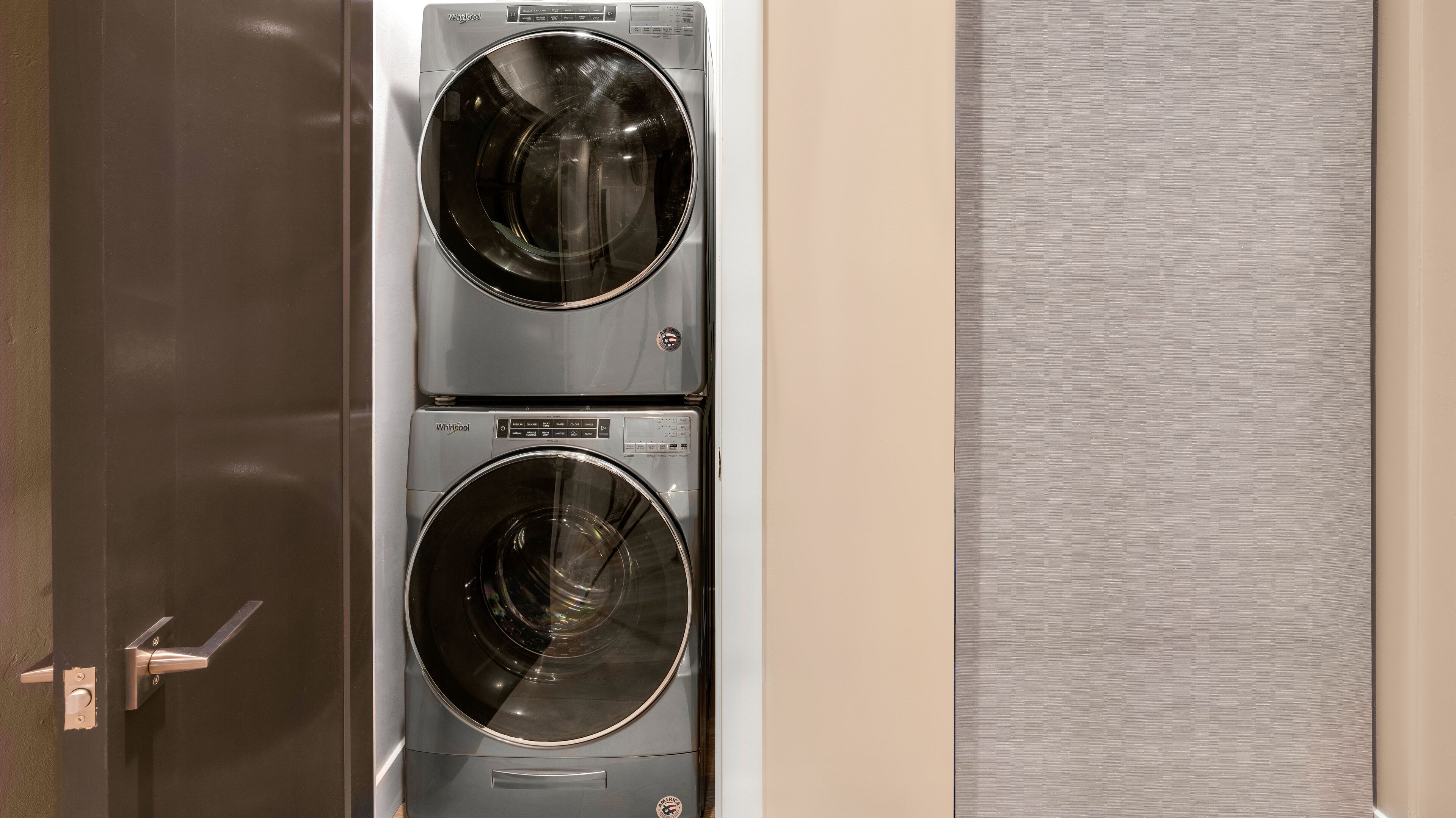 Een voorperspectief van een wasmachine en droger unit, gemonteerd aan de muur.