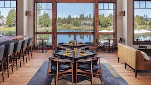 Un comedor espacioso con techo alto, ventanas amplias y vista a un lago.