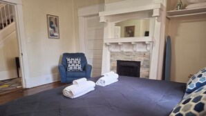 A bedroom with a bed, a chair, and a fireplace. - Charming 4BR Historic Home near Downtown & Duke, Spacious & Stylish (Durham)
