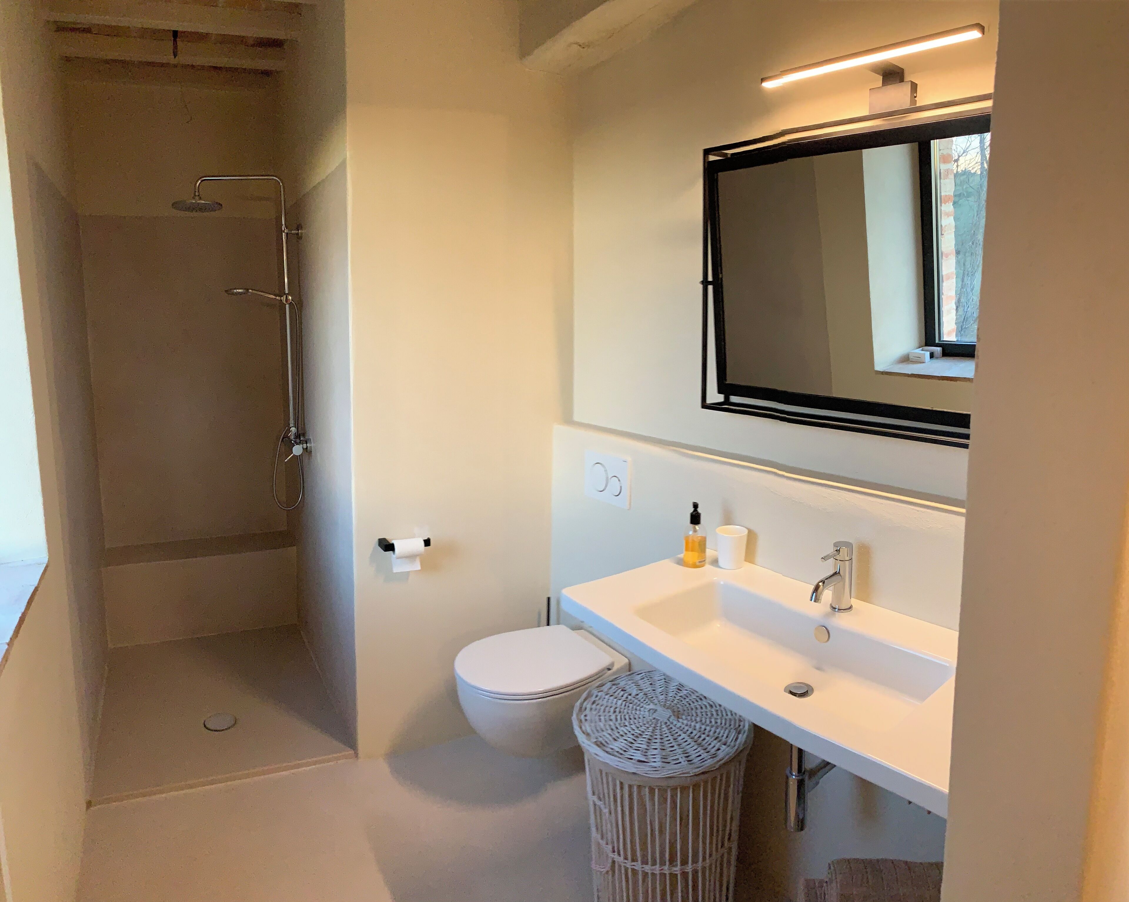 Une salle de bain moderne équipée d’une douche, de toilettes et d’un lavabo.
