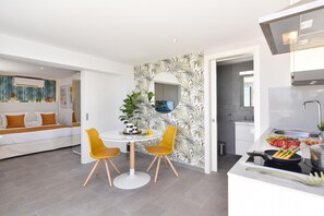 Een moderne keuken met een eethoek, een witte bank en een plant.