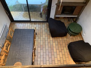 Una habitación pequeña y acogedora con cama, una mesa y una silla. Tiene chimenea y ventana con vistas al exterior.