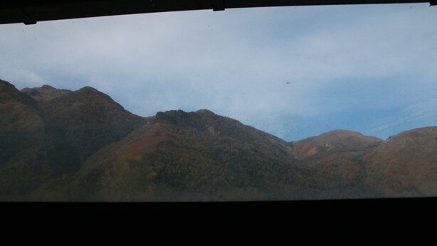 Paisaje montañoso con vista al cielo y montañas a lo lejos.