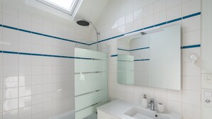 A modern bathroom with a glass shower enclosure, a large mirror, and a white sink with a vanity. - LE PETIT MARIUS - Cocon au cœur du centre-ville historique (Rennes)
