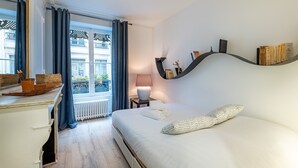 A modern hotel room with a large bed, a desk, and a view of the city. - Isadora - Ravissant T2 au coeur de Lyon (Lyon)