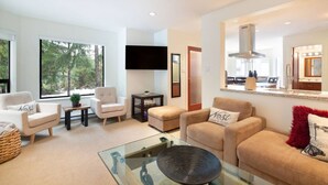 A modern living room with a sofa set, a coffee table, and a TV. - Prime Location: 4-Bedroom Chalet Style Home (Whistler)