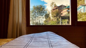 A room with a bed, a window, and curtains. - An artsy and peaceful mountain stay located in an offbeat village of Shoja (Banjar)