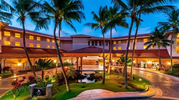 A resort with a central courtyard, palm trees, and a swimming pool. - Waiohai Beach Club - Island View (Kauai)
