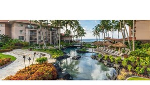 A resort with a pool, palm trees, and a view of the ocean. - Waiohai Beach Club - Island View (Kauai)