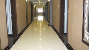Un pasillo largo, bien iluminado, con piso brillante y paredes de madera.