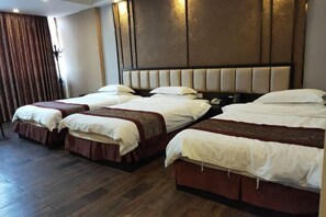 A hotel room with three beds arranged in a row, wooden flooring, and a modern headboard with built-in lighting. - Bairun Hotel (Ruyuan)