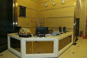 A reception desk with a clock, a menu board, and a decorative vase. - Bairun Hotel (Ruyuan)