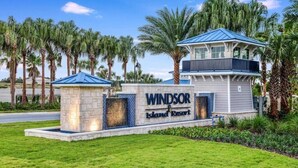 A resort entrance with a sign reading "Windsor Island Resort" and a building with a blue roof.