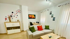 A modern living room with a sofa, a coffee table, and a cabinet. - SHR002 Nuevo y Moderno apartamento en Nerja con Patio (Nerja)