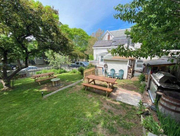 Enjoy an outdoor space surrounded by trees and a fence, perfect for a barbecue or picnic.