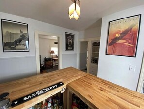 Enjoy a drink at the Sailor's Bar, complete with a storage cabinet and framed artwork.