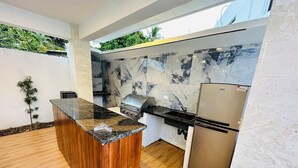 Eine moderne Küche mit einer Holzinsel, einer Marmor-Spritzschutzwand und Edelstahlgeräten.