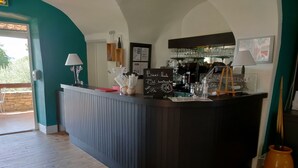 Eine Bar mit Theke, Gläsern und einer Tafel mit der Speisekarte.