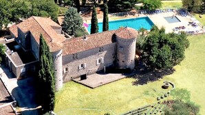 Una estructura que recuerda a un castillo, con piscina y cancha de tenis.