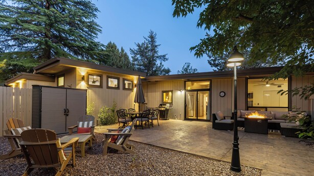 A covered outdoor patio with seating, a fire feature, and a lamp post. - Sedona Modern Mid-Century Walk to Hiking Trails, Natural Light, Dinner In The Yard! (Sedona)