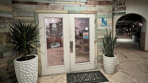 A building entrance with a sign reading "The Beach Buzz" and a closed door.