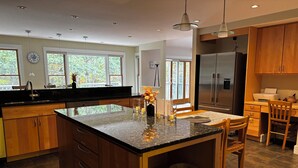 A modern kitchen with wooden cabinets, a granite countertop, and a stainless steel refrigerator. - Strawberry Hill A Deluxe Retreat, Close to Village 1.5 mi to Acadia (Bar Harbor)