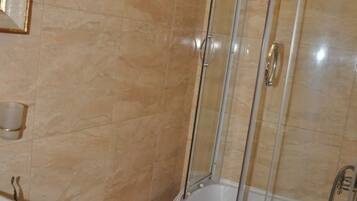Un bagno con doccia vetrata, un water bianco e un lavandino.