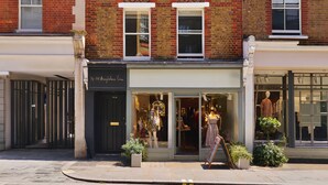 A row of red brick buildings with multiple windows, a storefront with mannequins, and a clear sky. - 74-78 Marylebone Lane (London)