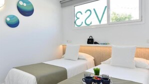 A hotel room with two beds, a window with a view, and wall art. - Velsuites (San Bartolome de Tirajana)