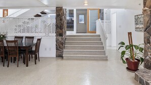A dining area with a table and chairs, a staircase leading to an upper level, and a potted plant. - Family Time and a Fire Pit 3 Bdr 2.5 Bth (Anchorage)