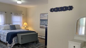 A bedroom with a bed, bedside table, lamp, and a painting of the ocean. - 🔥Warm, Spacious, Free Wine🍷Entire Apt, Self CheckIn! (Dover)