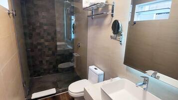 Un baño moderno con ducha, inodoro y lavamanos.