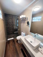 Un baño moderno con ducha, inodoro y lavamanos.