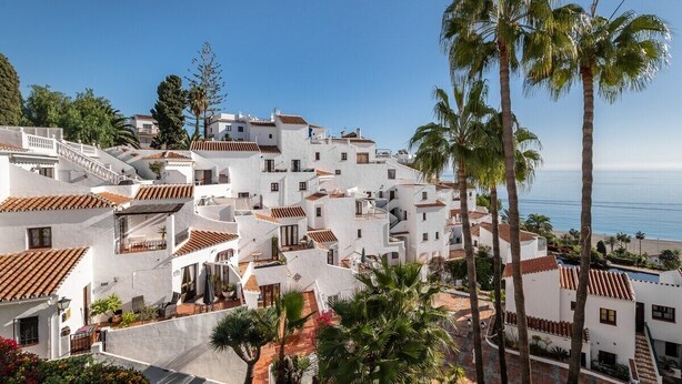 A coastal village with white buildings and terracotta roofs, surrounded by palm trees and a clear view of the sea. - SHR004 Smile Beach House. Incredible views. (Nerja)