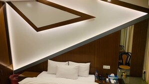 Ein modernes Hotelzimmer mit einem Bett, einem Nachttisch und einem Schreibtisch mit Stuhl.