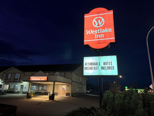 Señal de Westlake Inn con un mensaje sobre tarifas económicas y desayuno incluido.