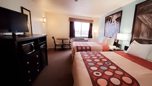 A hotel room with two beds, a TV, a desk, and a window with curtains. - Westlake Inn (Strathmore)