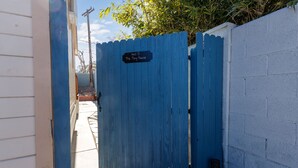 A blue gate with a sign reading "Unit D The Tiny House." - Private Tiny House Retreat with Spacious Patio, Free Parking & WiFi (Las Vegas)