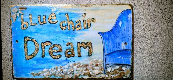 A sign with the text "Blue chair Dream" and a chair illustration. - Blue Chair Dream 1-102 (Cruz Bay)
