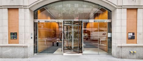 A building entrance with a glass door and a revolving door.