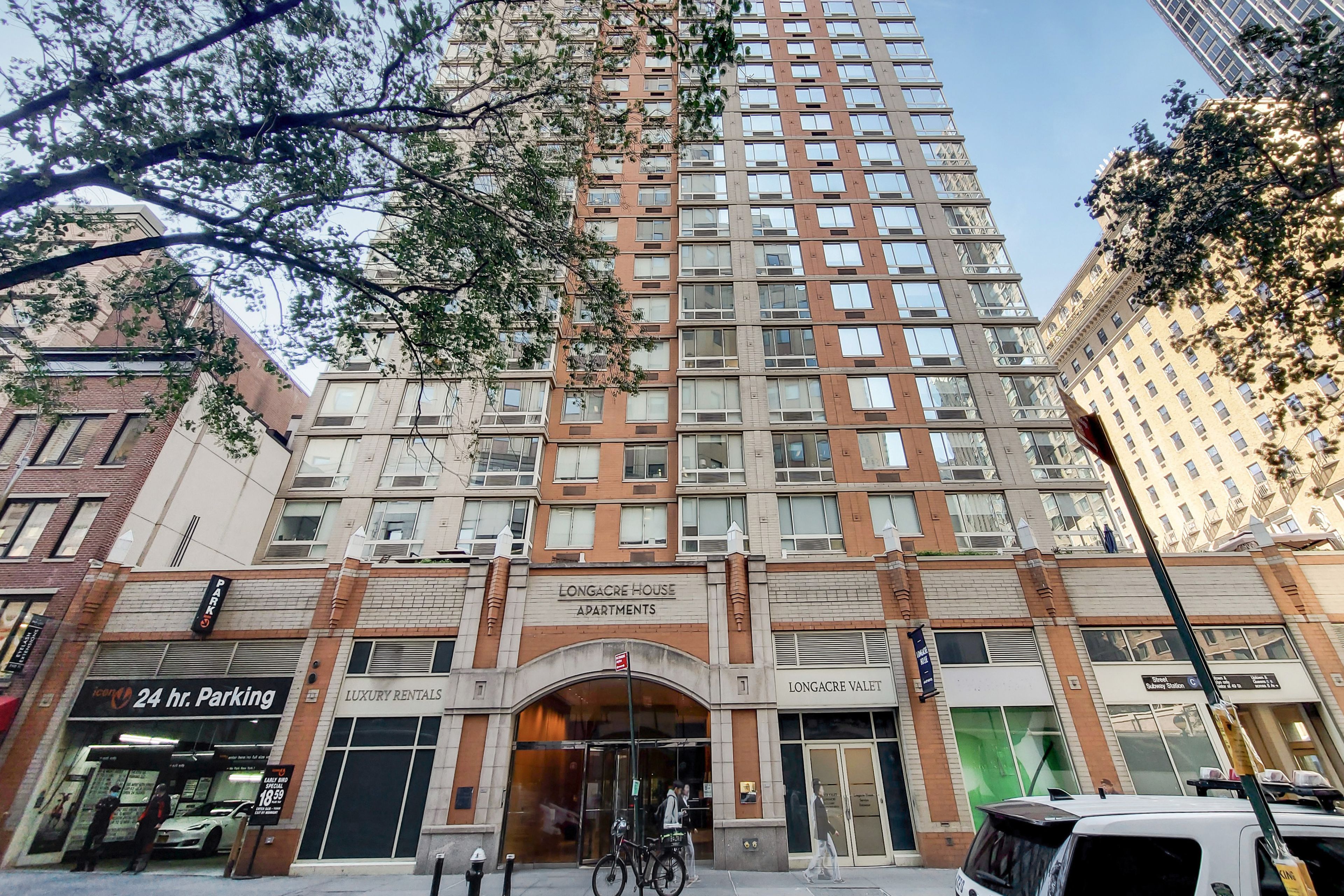 Ein mehrgeschossiges Gebäude mit einem markanten Eingang, auf dem "Longacre House Apartments" steht.