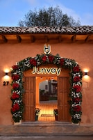 L’entrée d’un hôtel, avec une façade en bois, une enseigne indiquant « Junway » et une arche décorative ornée de fleurs.