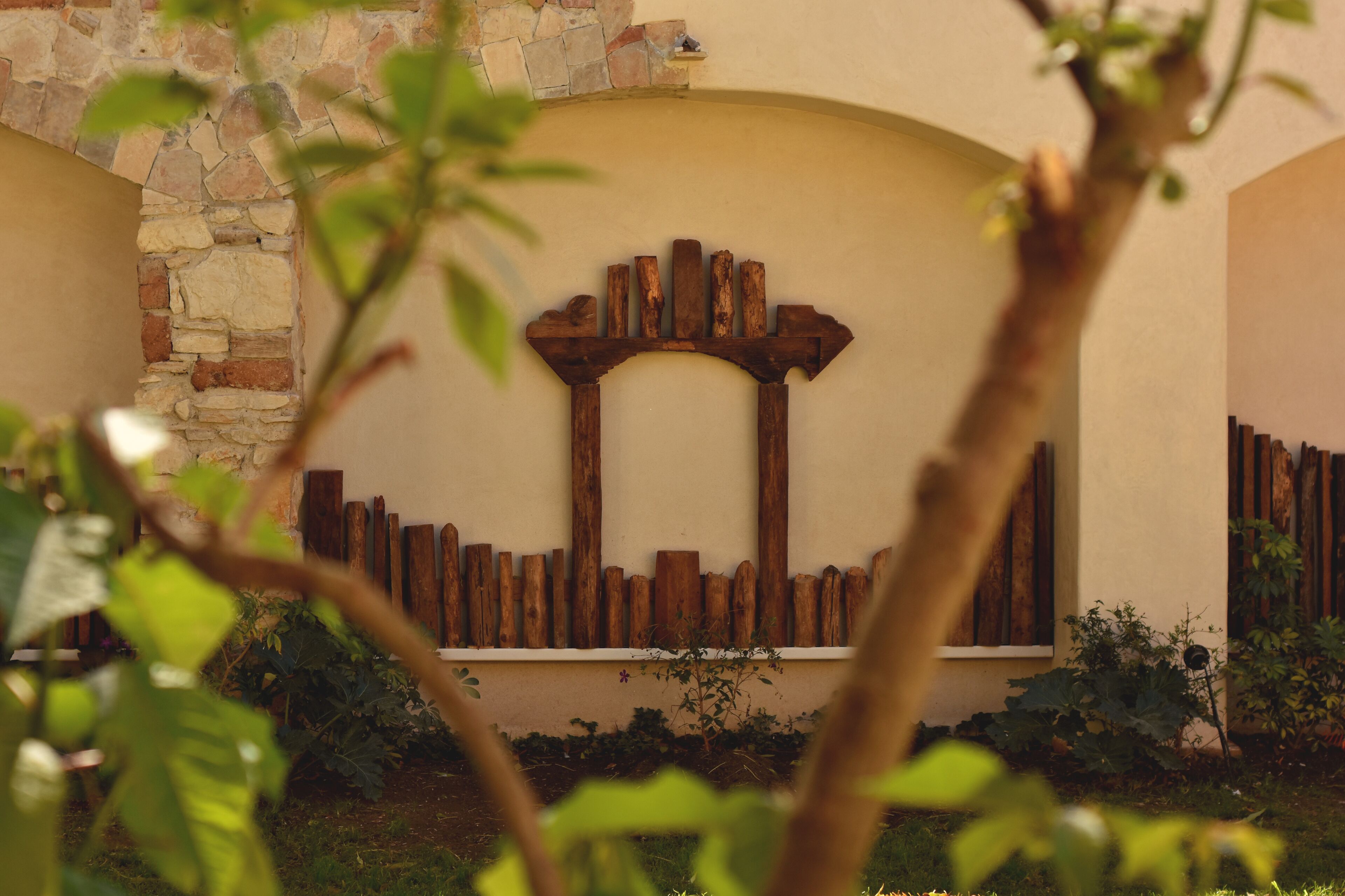 A stone wall with a wooden archway and a wooden fence.