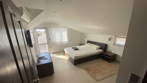 Een slaapkamer met een bed, nachtkastjes, een bureau en een raam.