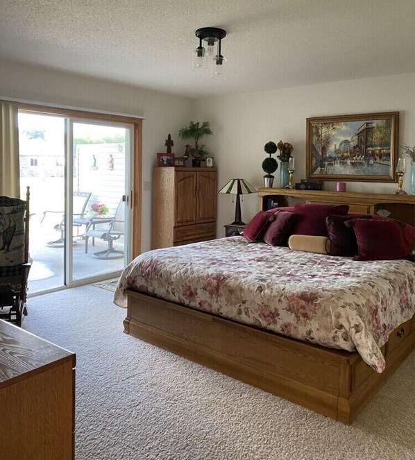 A bedroom with a bed, a dresser, a lamp, and a painting. - 1 level Golf Course Property think Golf/Hunting/Fishing/ATV’s/Snowmobiling (Mondovi)