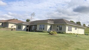 A two-story house with a front porch, a garage, and a well-maintained lawn. - 1 level Golf Course Property think Golf/Hunting/Fishing/ATV’s/Snowmobiling (Mondovi)