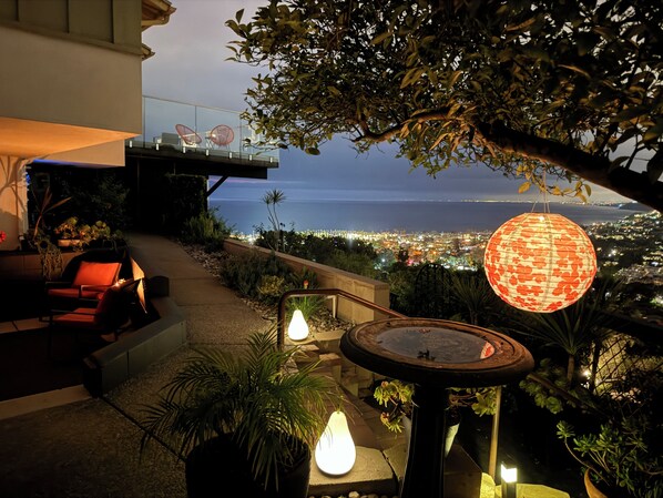 An outdoor seating area with a view of the city and the ocean.