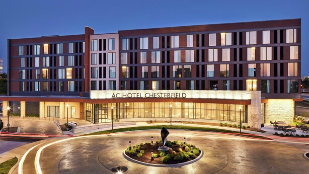 A modern hotel with a prominent entrance, a landscaped courtyard, and a well-lit facade. - AC Hotel by Marriott St. Louis Chesterfield (Chesterfield)