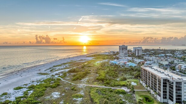 A coastal cityscape with a beach, a boardwalk, and modern buildings. - Endless Views | Walking Distance To Siesta Key Beach + Village w/ Rooftop Panoramic Views! (Siesta Key)